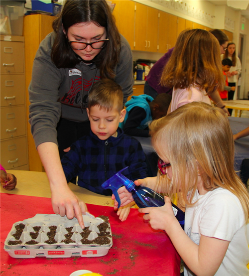 Students work together to water the newly planted seeds. 